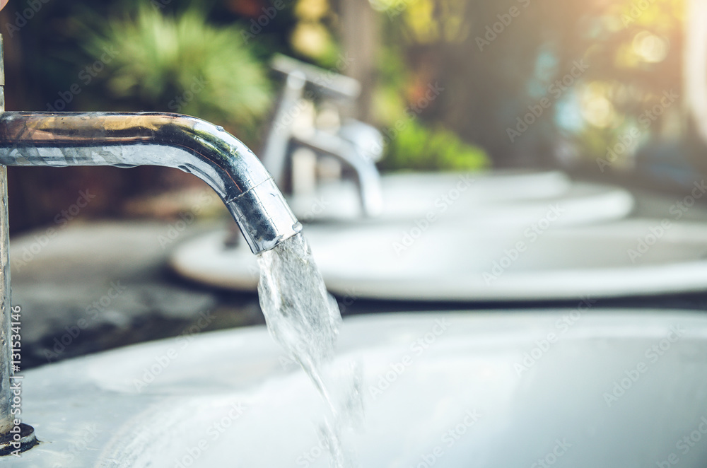 Water tap with water drop outdoor green park background Water tap with water drop outdoor green park background