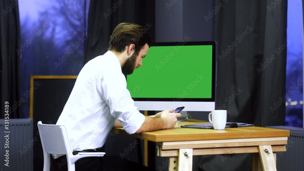 Young developer working at trendy start up office, checking his smartphone. Chroma key. 4K UHD 60 FPS slow motion Young developer working at trendy start up office, checking his smartphone. Chroma key. 4K UHD 60 FPS slow motion