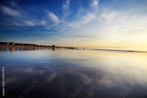 Early morning over a wide Maine beach at low tide  clouds reflected in the wet sands