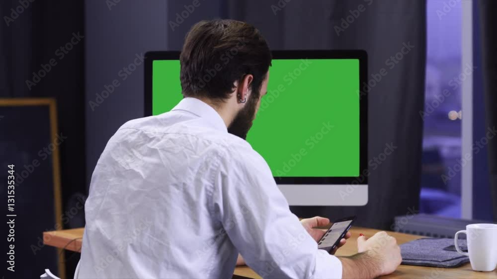 Young developer working at trendy start up office, checking his smartphone. Chroma key. 4K UHD 60 FPS slow motion Young developer working at trendy start up office, checking his smartphone. Chroma key. 4K UHD 60 FPS slow motion
