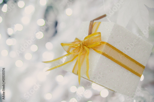 white Christmas gift box  with gold ribbon  and copyspace for your greeting or wishes photo