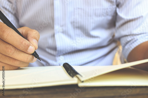 Hand write on the notebook with soft-focus in the background. over light and retro tone