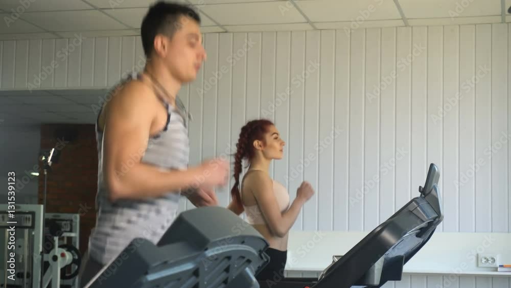 Man and woman running on treadmill
