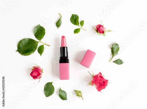 berry color decorative cosmetics with roses white background top view