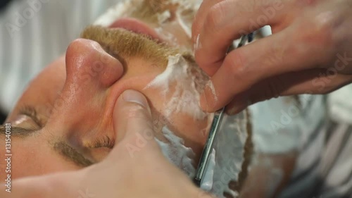 Client during beard shaving in barber shop