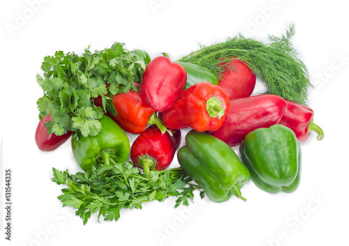 Several green and red bell peppers among the greens