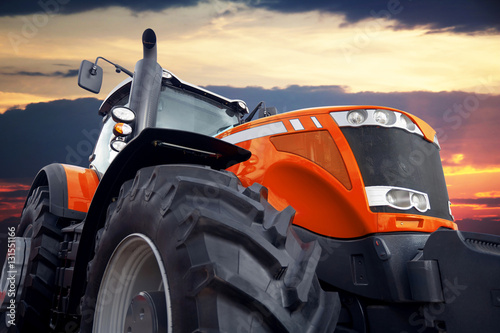 Fotografie Tractor on a background cloudy sky