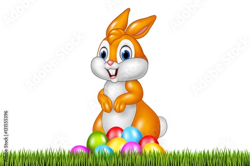 Easter bunny with decorated Easter eggs in a field © tigatelu