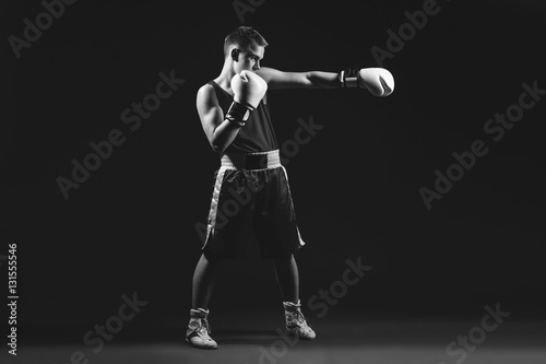 Young boxer sportsman on black background