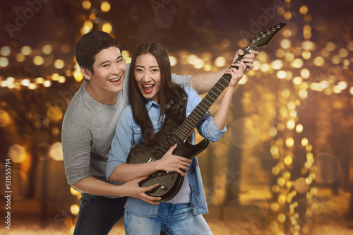 Romantic asian couple of lovers playing guitar