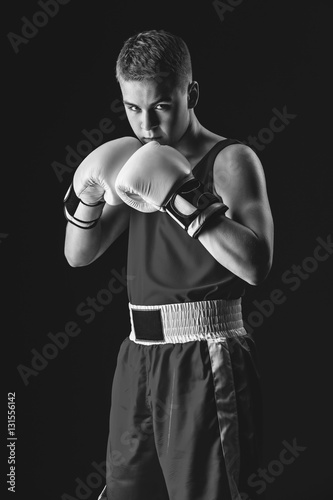 Young boxer sportsman on black background © svetography
