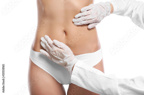 Surgeon examine female body before plastic operation on white background