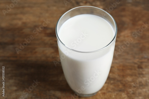 Glass of milk on blurred wooden background, closeup