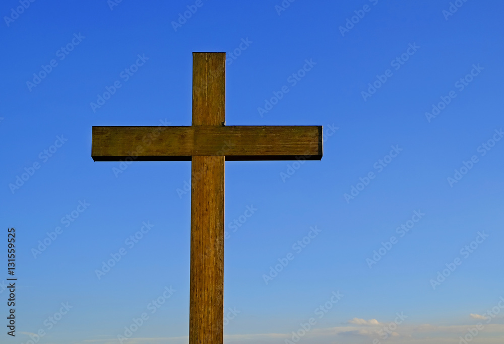 Wooden cross on sky background