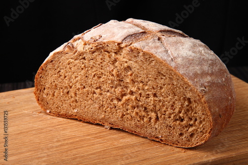 bread, cut on an oak board/ bread, cut on an oak board on a dark background