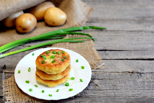 Roasted vegetable patties on a plate. Healthy patties cooked of potatoes, green peas, carrots and green beans. Vegetarian lunch or dinner idea. Fresh vegetables on wooden background with copy space