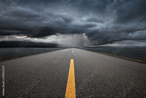 Photography Empty highway leading to the mountains through the rain.