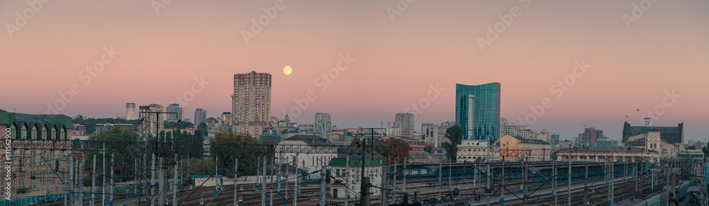 Fototapeta premium Moon over wide panorama of Kyiv city. Ukraine. Downtown and railways station.