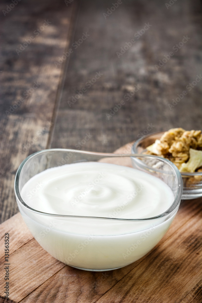 Greek yogurt in glass bowl on wooden table
Greek yogurt in glass bowl on wooden table