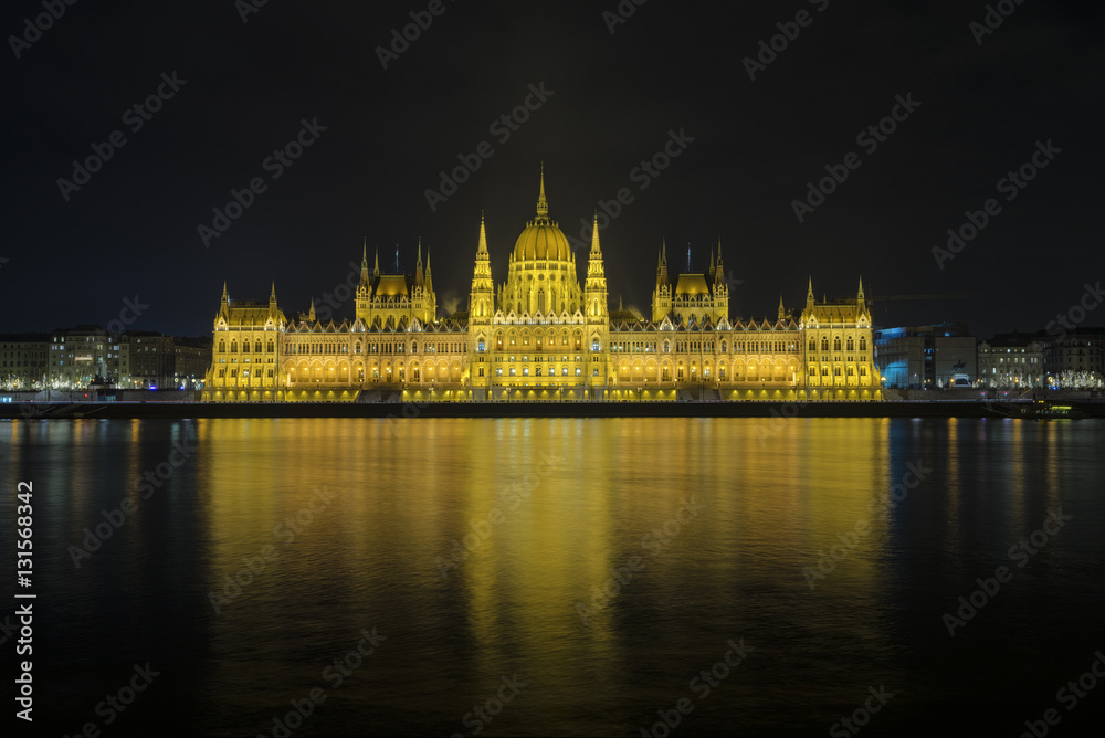 The view of Hungarian Parliament Building beside Danube River at Budapest, Hungary during night.