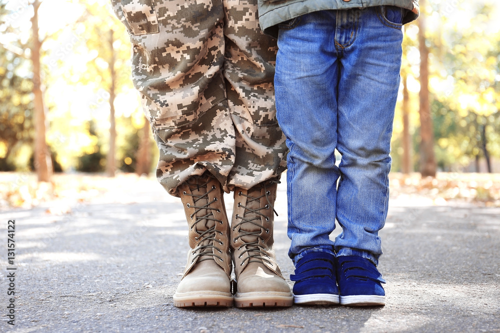 Mother soldier and little kid in the park. Closeup of legs Mother soldier and little kid in the park. Closeup of legs
