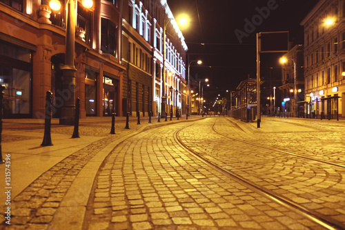 Empty tram rails in city at night time