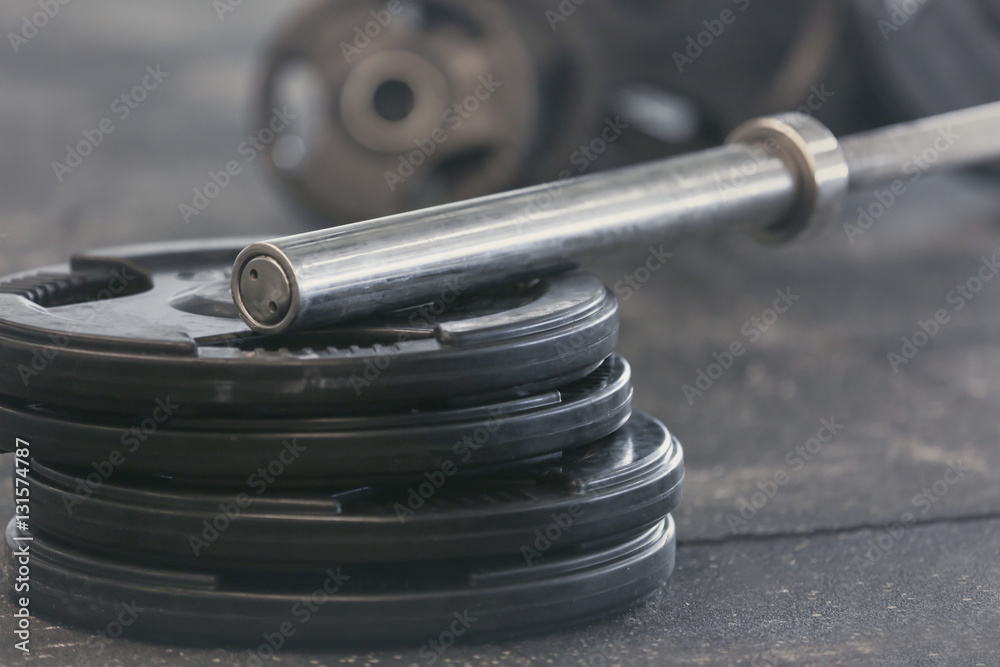 Disassembled barbell on floor in gym, close up Disassembled barbell on floor in gym, close up