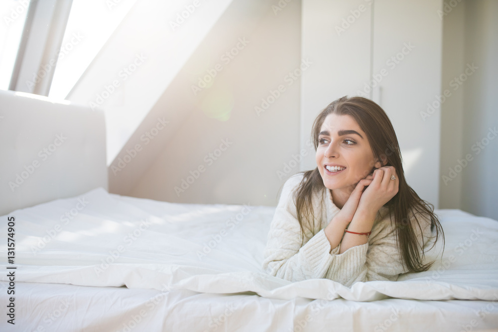 Happy woman lying on the bed and waking up in the morning Happy woman lying on the bed and waking up in the morning