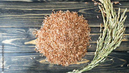 Top view of Brown rice  on black wood, rice plant with paddy on photo