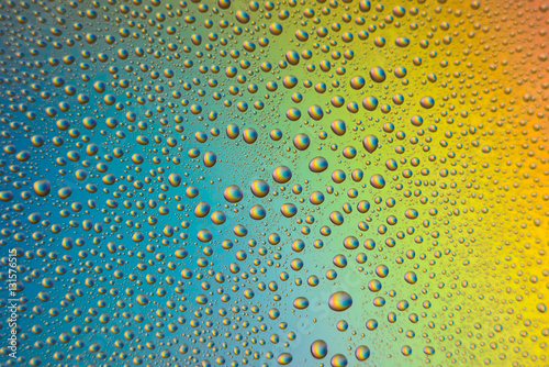 misted glass  drops closeup on rainbow colored background