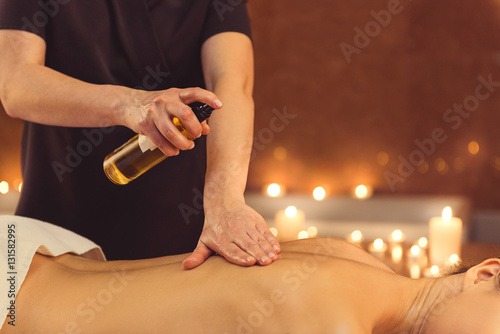 Skillful masseuse serving client at spa