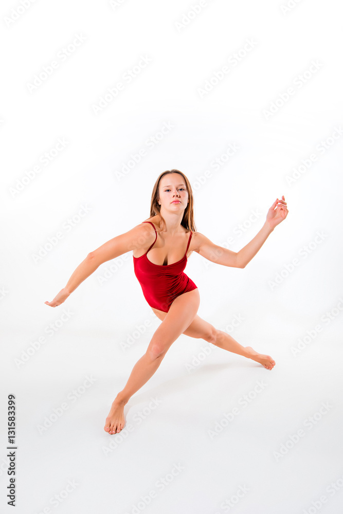 Young beautiful dancer in beige dress dancing on white background