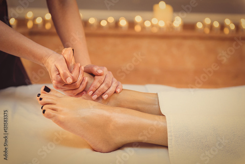 Skillful beautician undergoing feet massage
