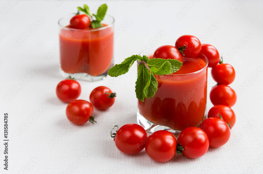 Tomatoes and juice in a glass on a light background Tomatoes and juice in a glass on a light background