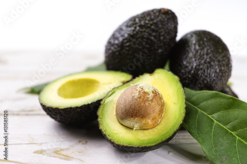 Green ripe avocado with leaves close up