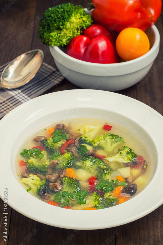 Vegetable soup with broccoli, mushrooms and herbs. Wooden background. Top view. Close-up Vegetable soup with broccoli, mushrooms and herbs. Wooden background. Top view. Close-up