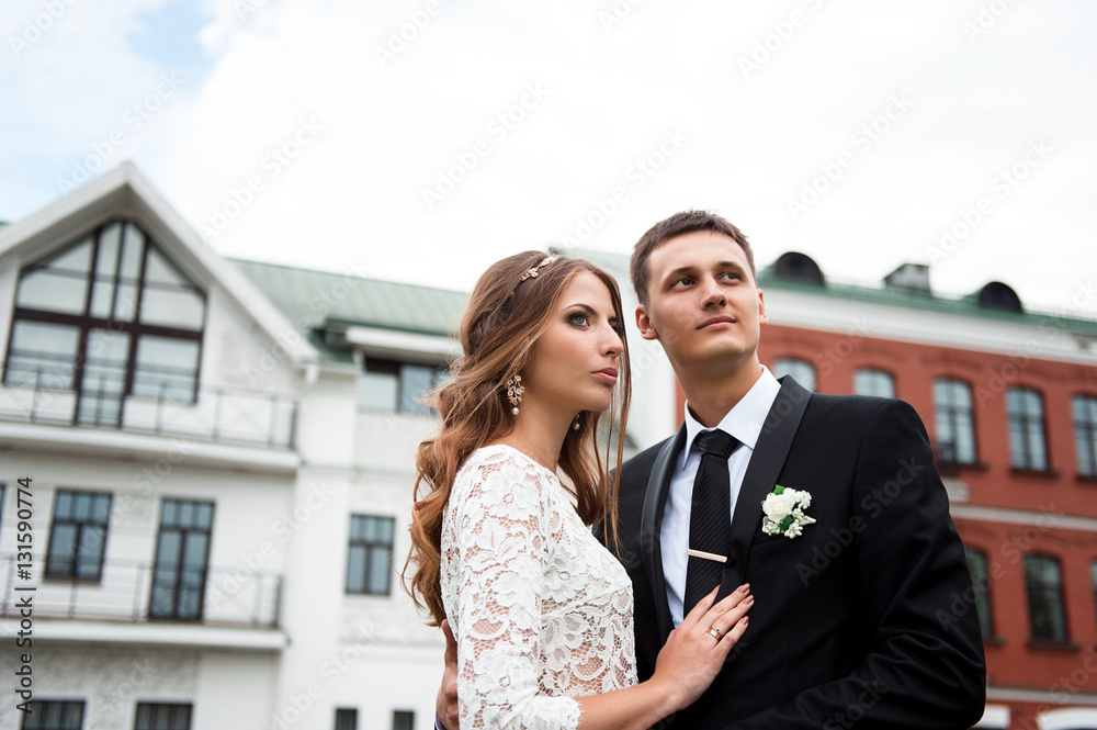 gorgeous happy wedding couple walking and kissing in the old city of Minsk, Belarus gorgeous happy wedding couple walking and kissing in the old city of Minsk, Belarus