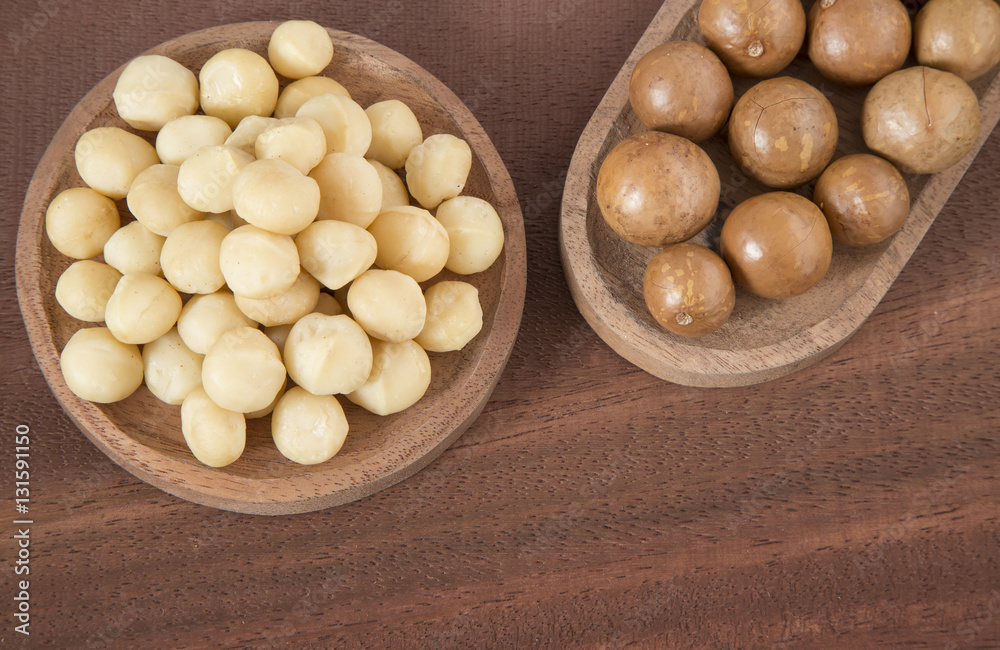 Macadamia nuts on the wooden background (Macadamia integrifolia) Macadamia nuts on the wooden background (Macadamia integrifolia)