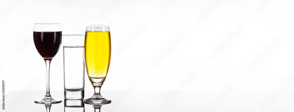 Rotwein, Bier und Mineralwasser in Gläsern vor weißem Hintergrund, Panorama