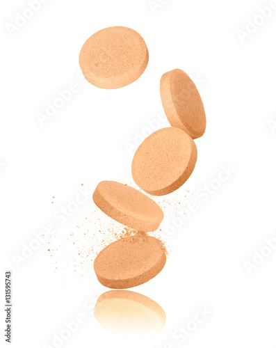 vitamins pills falling down closeup on white background