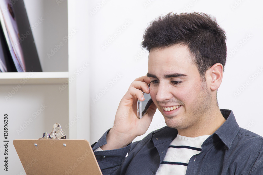 male young speaking by phone with the folder from the documents male young speaking by phone with the folder from the documents