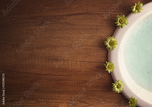 Sink on wooden tabletop with flowers around