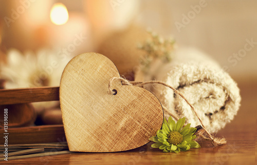 Wooden heart with towel, flowers and candles photo