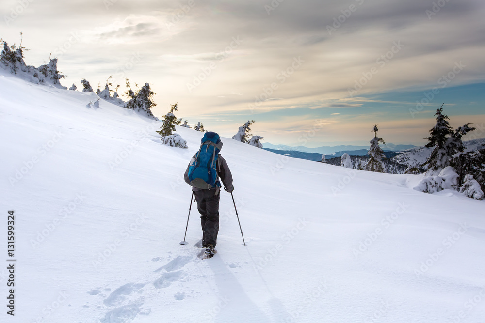 Man hiking in winter mountains before thunderstorm Man hiking in winter mountains before thunderstorm