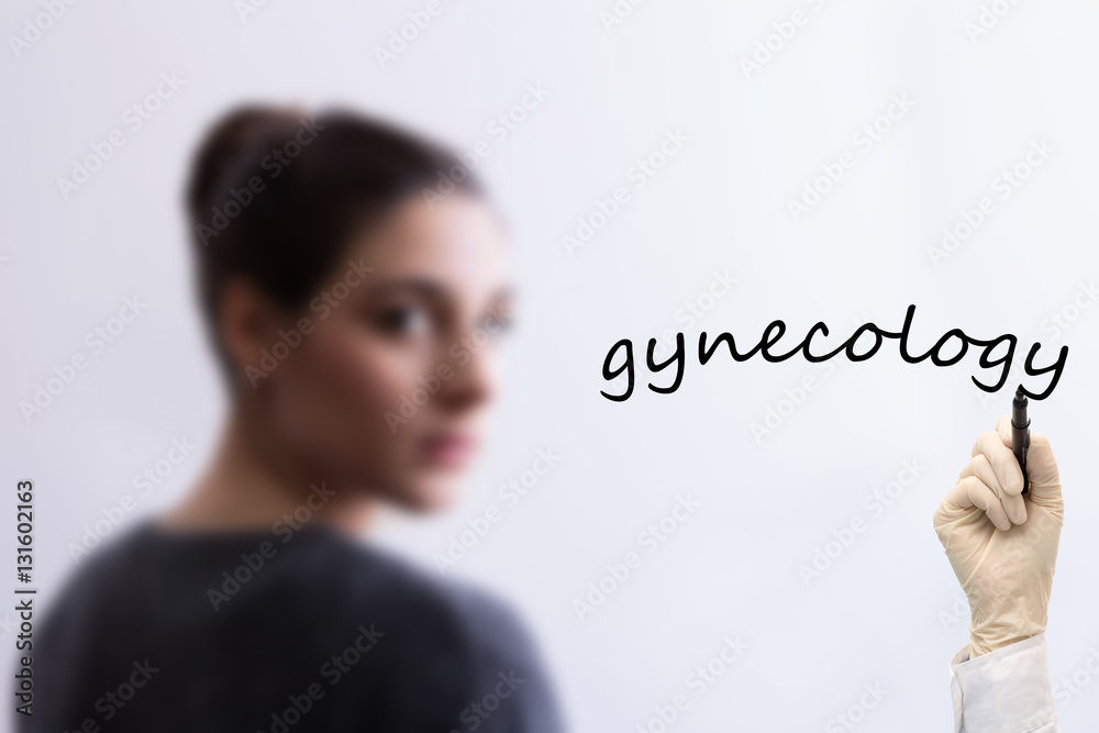 Blurred girl in background and hand writing ginecology Blurred girl in background and hand writing ginecology