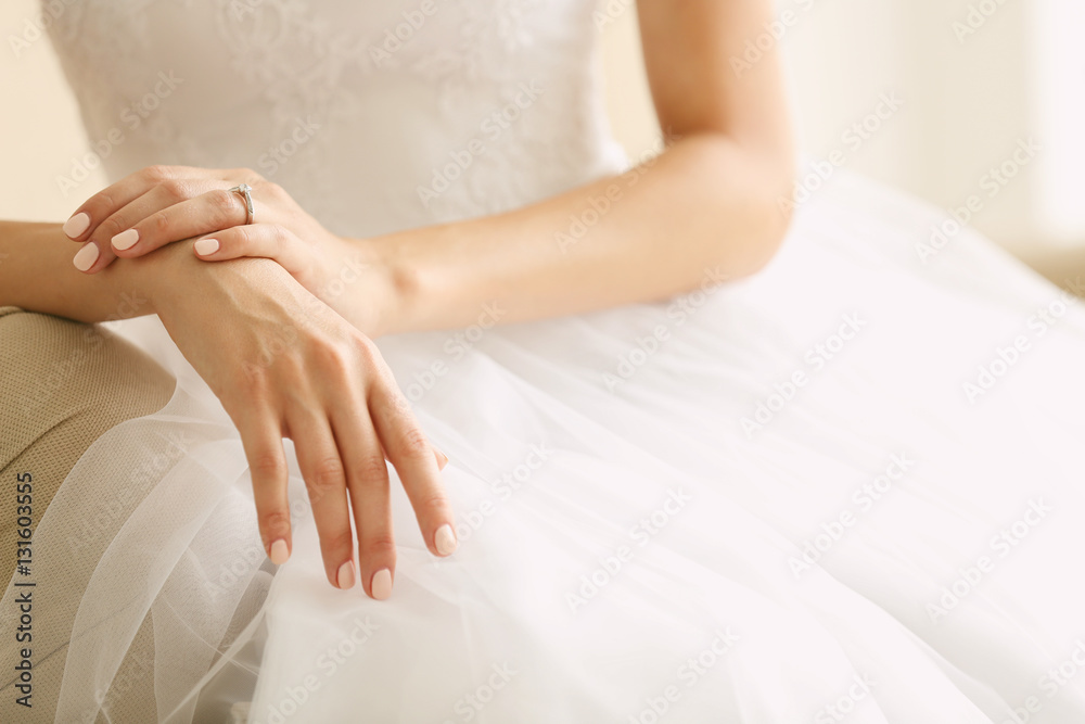 Bride in beautiful wedding gown sitting on sofa Bride in beautiful wedding gown sitting on sofa