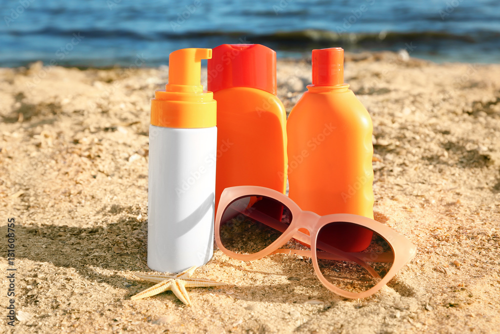 Sunscreen cream, sunglasses and starfish on sea coast Sunscreen cream, sunglasses and starfish on sea coast