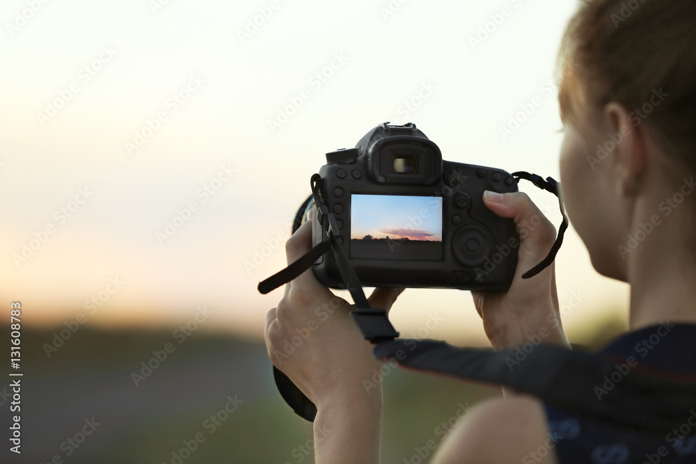 Obraz premium Woman with camera on natural blurred background