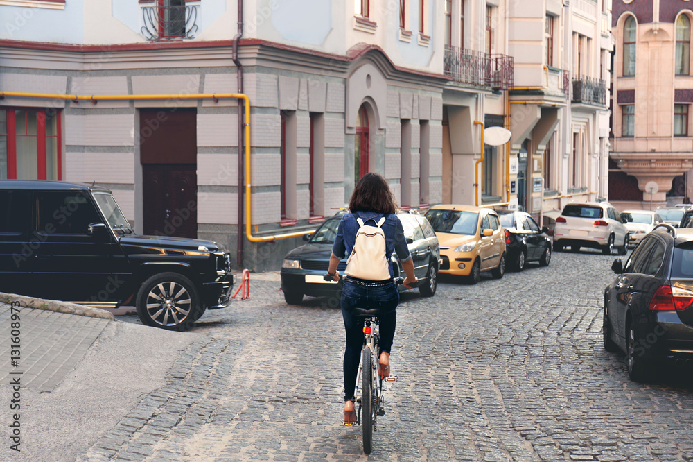 Pretty young woman riding bike outdoors