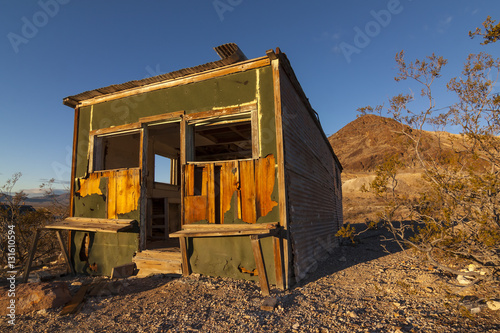 Old abandoned shack at Rhyolite Ghost Town in the Nevada Desert in early morning light with clear blue skies.